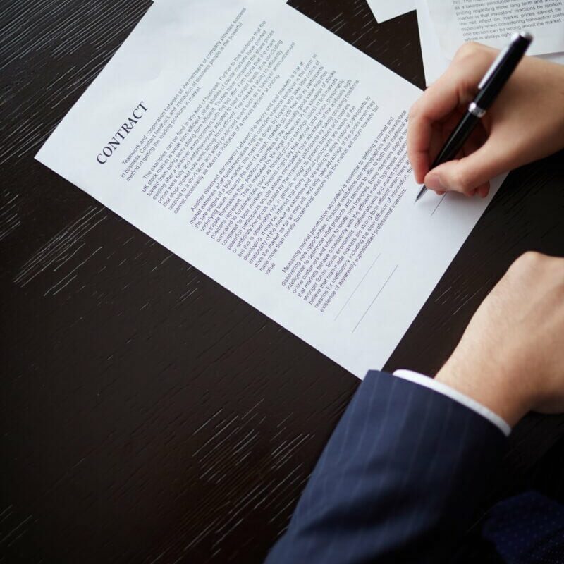 Business deal Image of businessman hand with pen signing contract at workplace